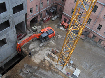 Выдача грунта грейферным экскаватором из-под возведенной наземной части здания во время разработки грунта на -2 этаже (способ "top & down").